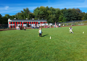 Zdjęcie przedstawia dzieci podczas zabaw sportowych - bieg do pachołka.