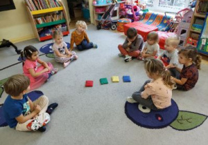 Zdjęcie przedstawia dzieci z młodszych grup wykonujące ćwiczenia z rozpoznawania kolorów.