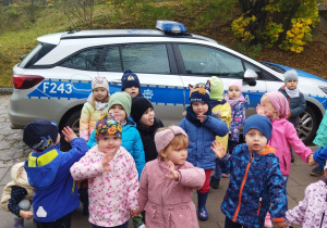 Na tym zdjęciu widać dzieci z grupy I przed samochodem policyjnym.