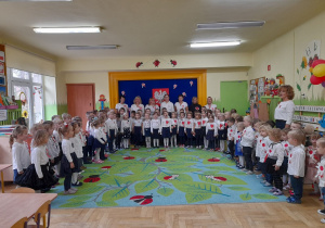 Zdjęcie przedstawia dzieci ze wszystkich grup, również "Muchomorki" podczas śpiewania Hymnu Narodowego.