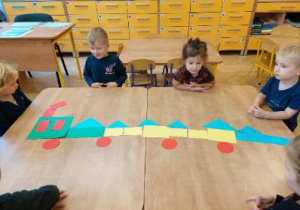 Zdjęcie przedstawia dzieci z grupy I podczas zabawy z figurami geometrycznymi.