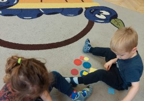 Na tym zdjęciu widać dzieci układjące wzorki z mozaiki geometrycznej.