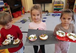 Zdjęcie przedstawia dzieci prezentujące efekty swojej pracy, czyli "serowe pyszczki".