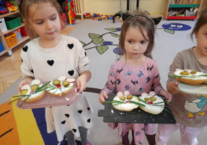 Zdjęcie przedstawia dzieci prezentujące efekty swojej pracy, czyli "serowe pyszczki".
