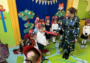 Zdjęcie przedstawia dzieci i panią Dyrektor, która magicznym ołówkiem pasuje je na przedszkolaka w grupie "Biedronek".