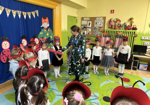 Zdjęcie przedstawia dzieci i panią Dyrektor, która magicznym ołówkiem pasuje je na przedszkolaka w grupie "Biedronek"