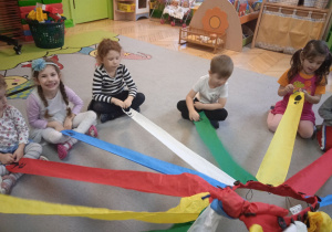 Zdjęcie przedstawia dzieci podczas zabaw z wiatrakiem matematycznym.