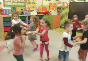 Zdjęcie przedstawia dzieci z grupy II podczas zabawy ruchowej.