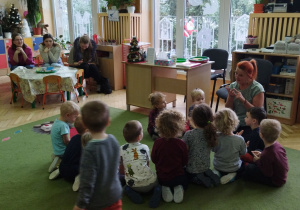 Zdjęcie przedstawia dzieci wraz z nauczycielką podczas zajęcia.