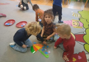 Zdjęcie przedstawia dzieci manipulujące kropelkami.