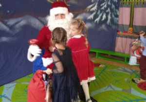 Na tym zdjęciu widać dziewczynki z grupy II odbierające prezent od Mikołaja.