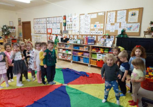 Zdjęcie przedstawia dzieci podczas zabaw z chustą animacyjną utrwalających kolory.