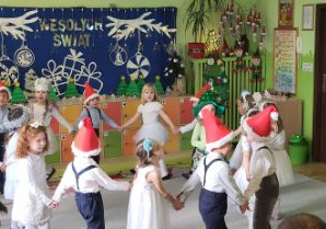 Zdjęcie przedstawia dzieci wykonujące układ taneczny.