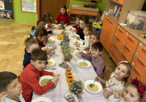 Zdjęcie przedstawia dzieci z grupy IV przy wspólnym, świątecznie zastawionym stole.