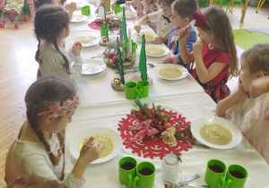 Zdjęcie przedstawia dzieci z grupy II przy wspólnym, świątecznie zastawionym stole.