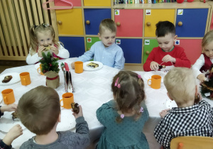 Zdjęcie przedstawia dzieci przy wspólnym, świątecznie zastawionym stole.