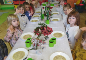 Zdjęcie przedstawia dzieci przy wspólnym, świątecznym stole.