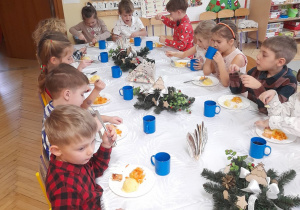 Zdjęcie przedstawia dzieci podczas obiadu przy wspólnym stole.