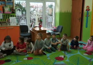 Zdjęcie przedstawia dzieci słuchające bajki.