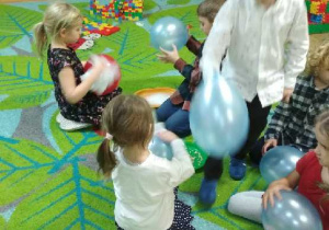 Zdjęcie przedstawia dzieci zgrupy III wykonujące odświadczenia z balonami.