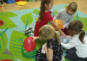 Na tym zdjęciu widać dziewczynki z grupy III wykonujące doświadczenia z balonami.
