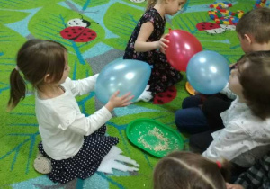 Na tym zdjęciu widać dzieci z grupy III wykonujące doświadczenia z balonami.