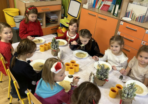 Na tym zdjęciu widać dzieci podczas świątecznego obiadu przy wspólnym stole.