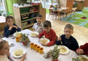 Na tym zdjęciu widać dzieci podczas świątecznego obiadu przy wspólnym stole.