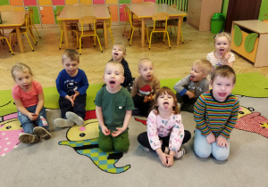 Zdjęcie przedstawia dzieci z najmłodszej grupy podczas wykonywania ćwiczeń narządó mowy.