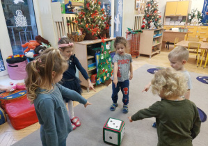Zdjęcie przedstawia dzieci z grupy I i II podczas zabaw matematycznych z kostką.