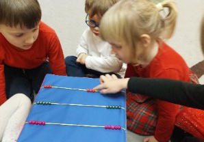 Zdjęcie przedstawia dzieci z grupy II podczas zabaw z kostką matematyczną.
