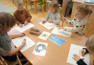 Zdjęcie przedstawia dzieci wykonujące pracę plastyczną podczas zajęć.