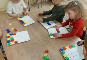 Zdjęcie przedstawia dzieci z grupy I manipulujące kolorową mozaiką.
