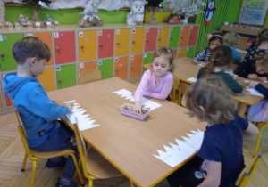 Zdjęcie przedstawia dzieci ozdbiające papierowe korony.