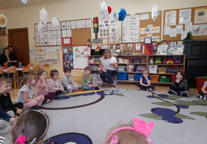 Zdjęcie przedstawia dzieci rozwiązujące zagadki podczas zajęcia.