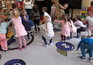 Zdjęcie przedstawia dzieci podczas zabawy ruchowej ''Zrób tyle, ile wskazuje cyfra".