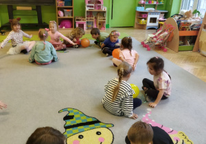 Zdjęcie przedstawia dziec i z grupy III podczas zabawy oddechowej "Wesołe baloniki".