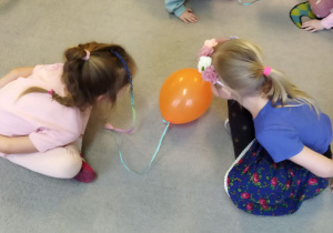Na tym zdjęciu widać dziewczynki z grupy III podczas zabawy oddechowej "Wesołe baloniki".