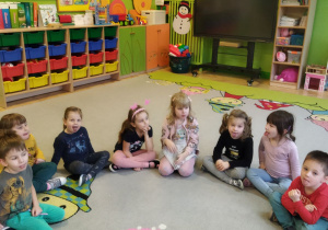 Zdjęcie przedstawia dzieci z grupy II podczas zabawy ćwiczącej narządy mowy "Poczęstuenk"..