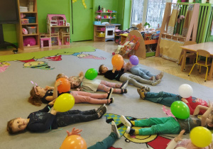 Na tym zdjęciu widać dzieci z grupy II podczas zabawy oddechowej "Wesołe baloniki".