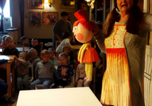 Na tym zdjęciu widać aktorkę, która prezentuje lalkę Ady występującej w przedstawieniu.