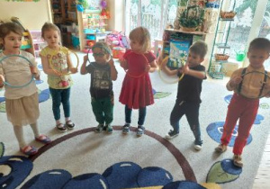 Zdjęcie przedstawia dzieci z grupy II podczas zabawy z kołami "serso" utrwalającej stosunki przestrzenne.