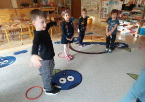Zdjęcie przedstawia dzieci z grupy I i II podczas zabawy z kołami "serso" utrwalającej stosunki przestrzenne.