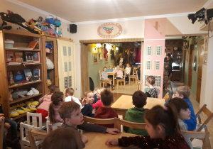 Zdjęcie przedstawia wnętrze kawiarenki oraz dzieci siedzące przy stolikach.