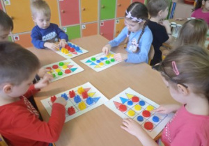 Zdjęcie przedstawia dzieci z grupy II podczas zabaw matematycznych.