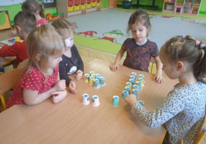 Zdjęcie przedstawia dzieci z grupy I i II podczas gry z wykorzystaniem jednorazowych kubeczków.