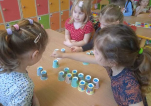 Zdjęcie przedstawia dzieci z grupy I i II podczas gry z wykorzystaniem jednorazowych kubeczków.