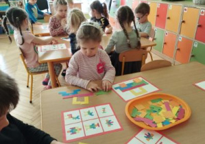 Zdjęcie przedstawia kolejne dzieci układające tangramy.