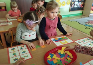 Zdjęcie przedstawia dzieci z grupy I i II układjące tangramy.