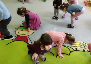 Zdjęcie przedstawia dzieci z grupy II podczas zabawy ruchowej połączonej z ćwiczeniami artykulacyjnymi.